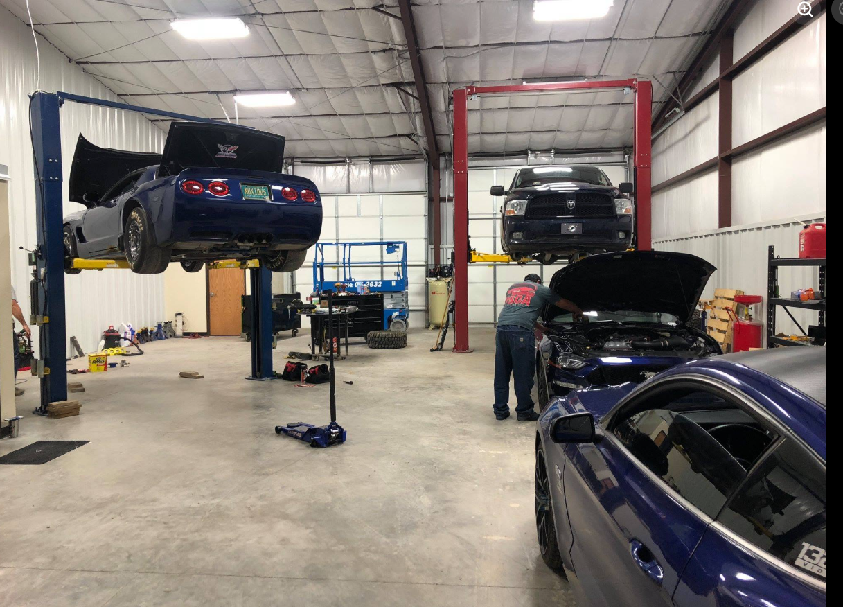 Busy shop floor with multiple vehicles on lifts