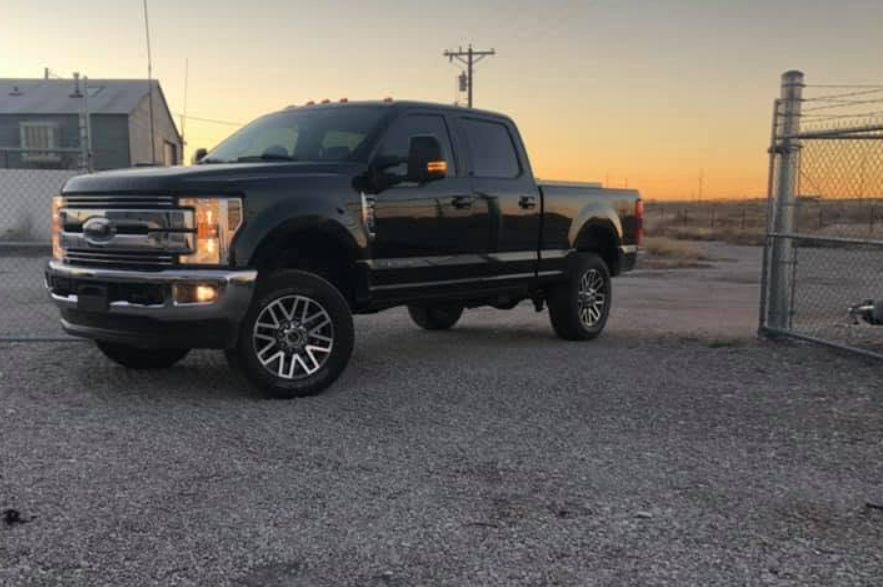 Black lifted Ford truck at sunset