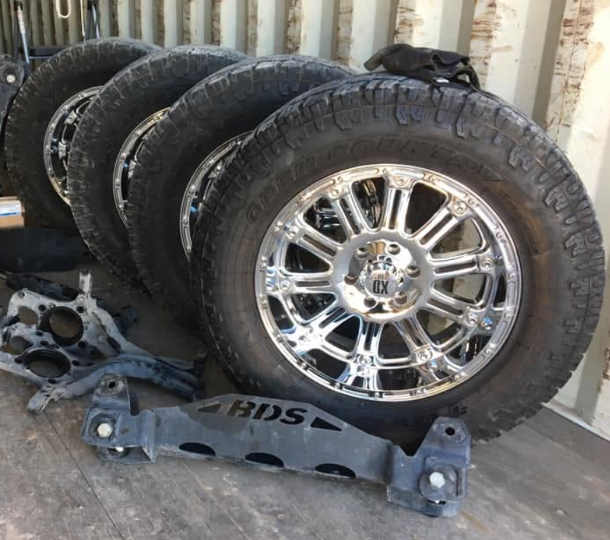 Stack of off-road tires and chrome wheels